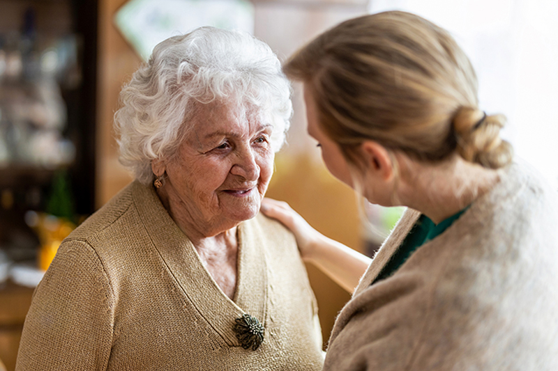 happy-caregiver-comforting-senior-lady