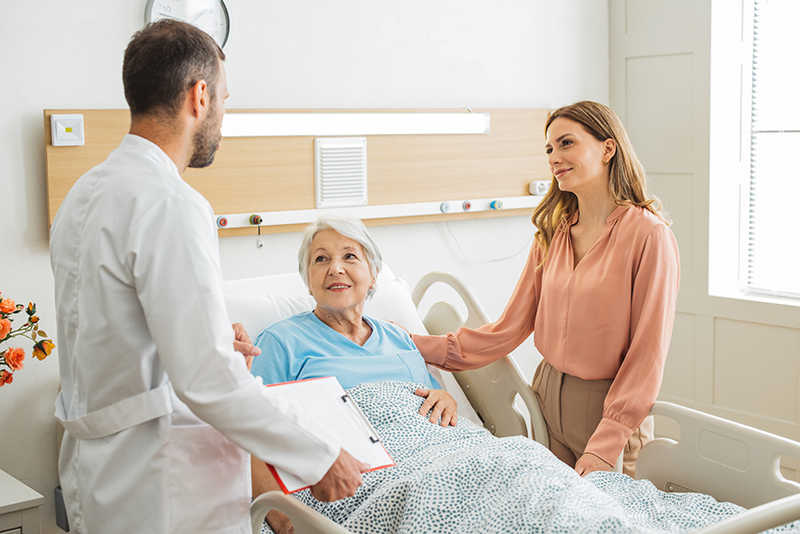Woman standing with doctor and elderly loved one at the hospital, putting senior advocacy tips into practice to make sure the senior receives the best care