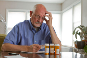 A senior man reviews his prescription medications that may increase fall risk.