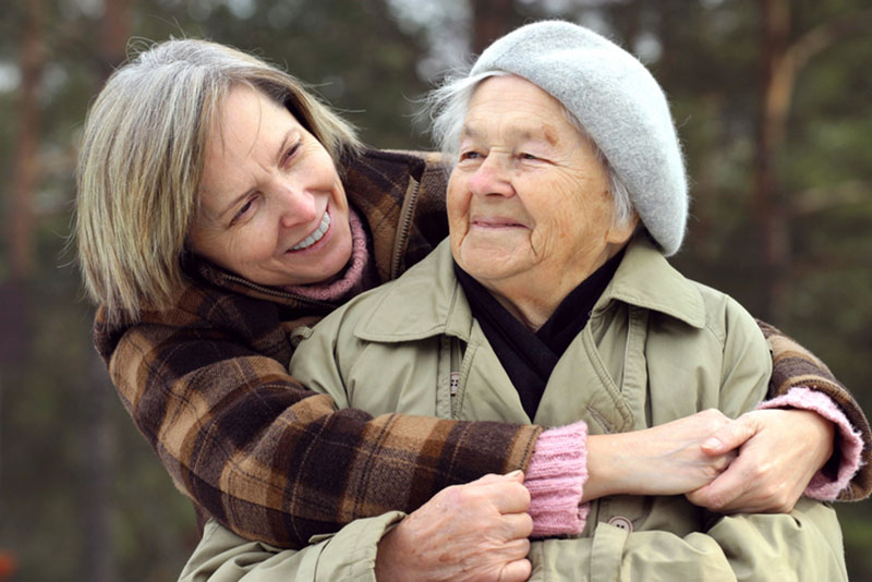An adult woman who has taken on a family caregiving role spends time with her elderly mother.