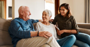 An adult woman spends time with her older parents, something that many only-child caregivers do each day.