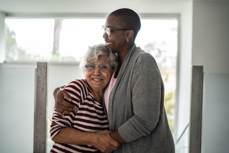 A woman embraces her mother who suffers from anxiety. She understands there is a connection between anxiety and older adults and is helping her mother find strategies to manage the condition.